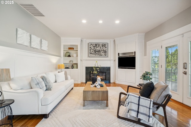 1365 NW 96th Ave, Portland, OR 97229 - living room with recessed lighting, a tiled fireplace, light wood-style flooring, and built in features