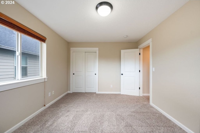 unfurnished bedroom with carpet flooring and a closet