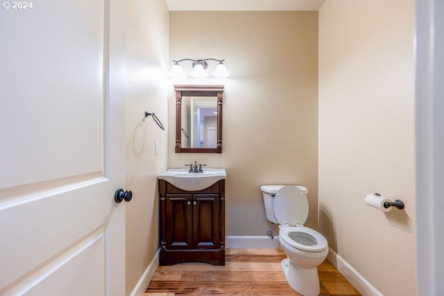 bathroom with vanity, wood-type flooring, and toilet