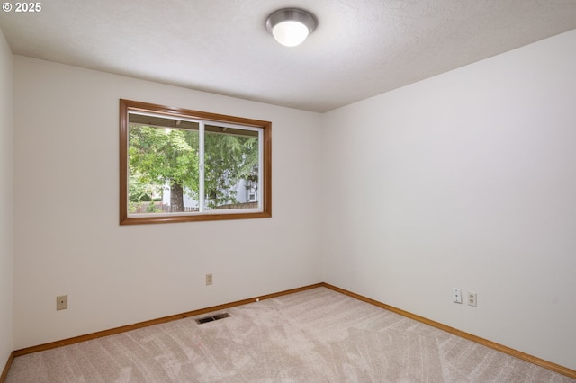 empty room with baseboards and light colored carpet