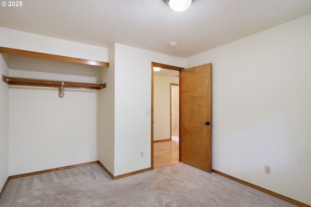 unfurnished bedroom with light colored carpet and baseboards