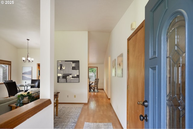 foyer entrance featuring light wood-type flooring and a chandelier