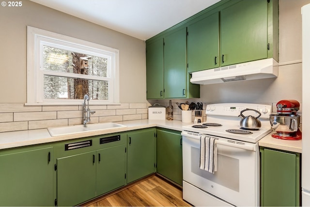 kitchen featuring sink, tasteful backsplash, light hardwood / wood-style flooring, green cabinets, and white range with electric stovetop