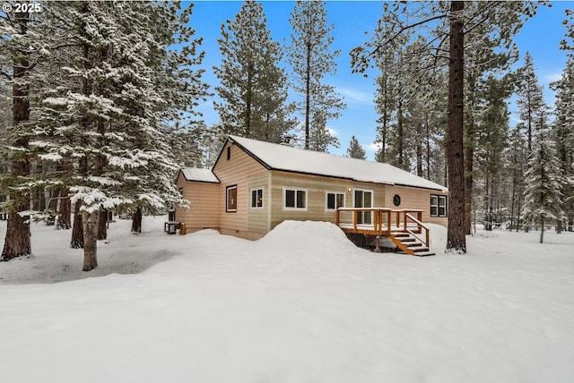 snow covered property with a deck