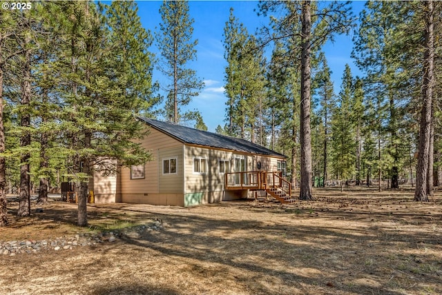view of side of home with metal roof and a deck