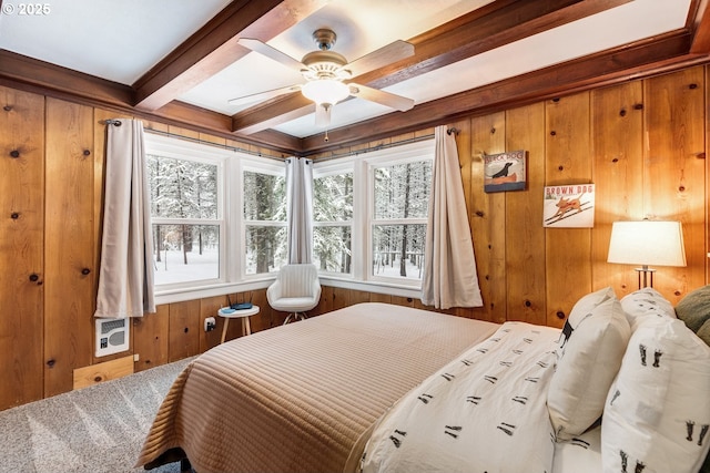 bedroom featuring beamed ceiling, wooden walls, and a ceiling fan