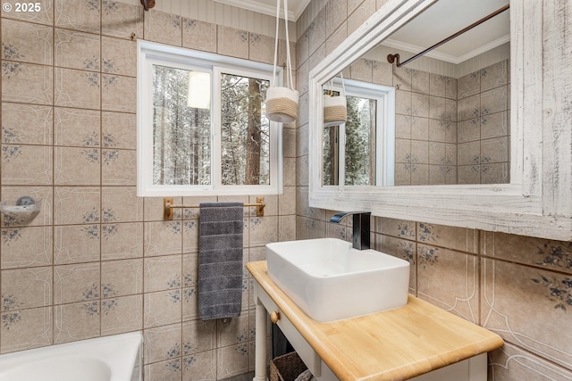 bathroom featuring crown molding, a healthy amount of sunlight,  shower combination, and tile walls