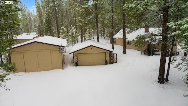 view of front of home with a garage and an outbuilding