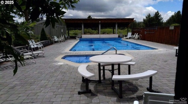 view of pool featuring an in ground hot tub and a patio