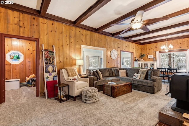 carpeted living room with a baseboard heating unit, beam ceiling, ceiling fan with notable chandelier, and wood walls