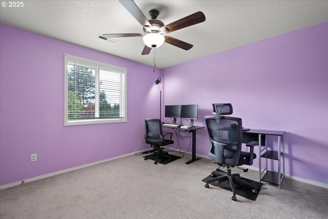 office with baseboards, visible vents, carpet floors, and ceiling fan
