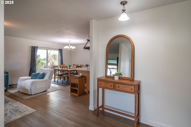 interior space featuring wood finished floors, baseboards, and a chandelier