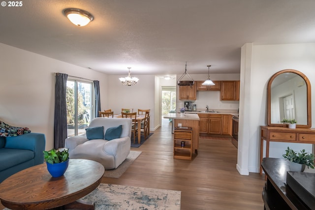 living room featuring baseboards, a notable chandelier, and wood finished floors