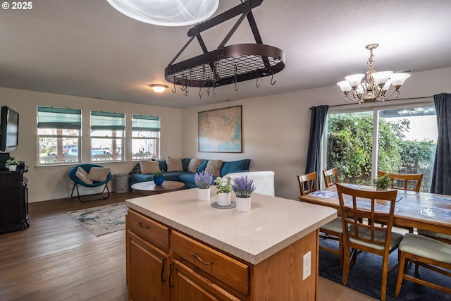 kitchen featuring a wealth of natural light, a notable chandelier, open floor plan, and brown cabinetry