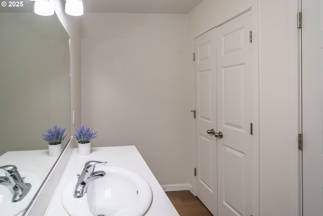 bathroom with vanity, baseboards, and wood finished floors