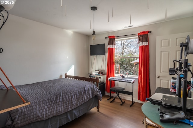 bedroom featuring visible vents and wood finished floors