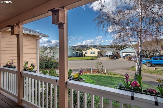 deck with a garage, a residential view, and a lawn