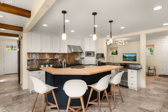 3184 SW 73rd Ave, Portland, OR 97225 - kitchen with butcher block countertops, recessed lighting, under cabinet range hood, white cabinetry, and appliances with stainless steel finishes