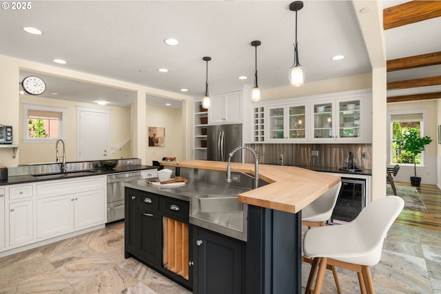 3184 SW 73rd Ave, Portland, OR 97225 - kitchen featuring white cabinetry, butcher block counters, appliances with stainless steel finishes, and a sink