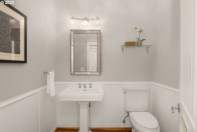 3184 SW 73rd Ave, Portland, OR 97225 - bathroom featuring toilet, a sink, a decorative wall, and a wainscoted wall
