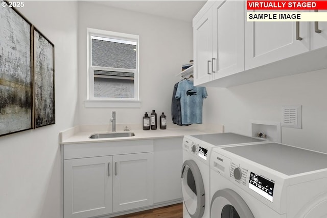 laundry area featuring cabinets, sink, washer and clothes dryer, and light hardwood / wood-style flooring