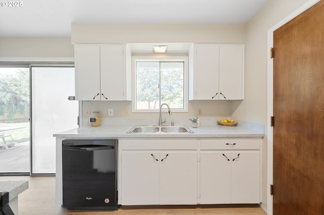 kitchen with black dishwasher, a sink, light countertops, and healthy amount of natural light