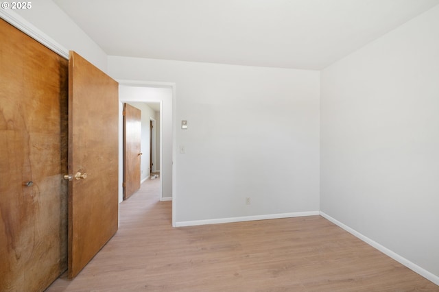 unfurnished room with baseboards and light wood finished floors
