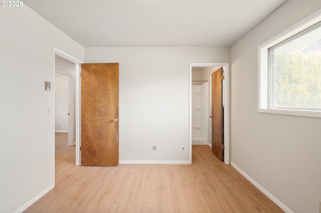 unfurnished bedroom with light wood-type flooring and baseboards