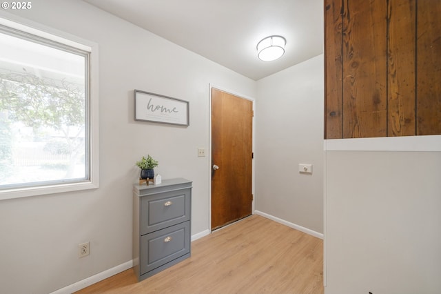 doorway to outside featuring light wood-style flooring and baseboards