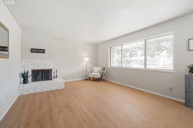 unfurnished room with wood finished floors, baseboards, and a fireplace