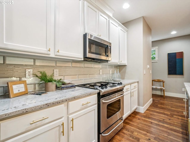 kitchen featuring wood finished floors, recessed lighting, white cabinets, tasteful backsplash, and appliances with stainless steel finishes