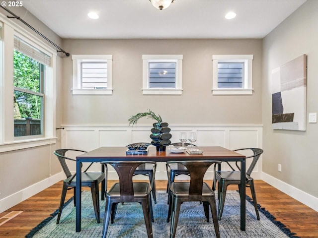 dining room with recessed lighting, dark wood finished floors, and a wainscoted wall