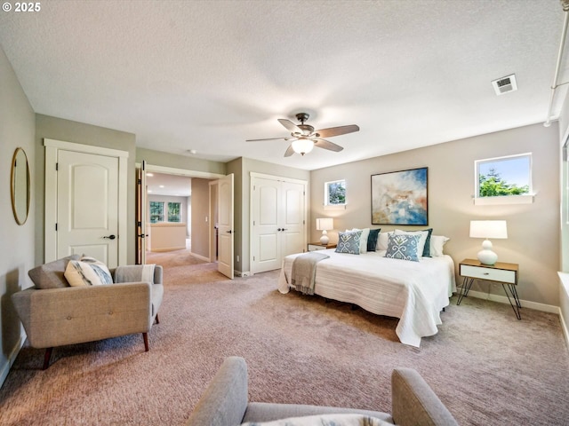 bedroom with visible vents, baseboards, light carpet, and multiple windows
