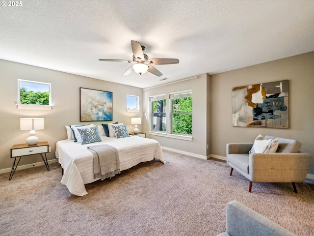 carpeted bedroom with baseboards, a textured ceiling, ceiling fan, and visible vents
