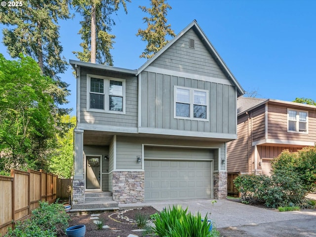craftsman-style home with a garage, fence, stone siding, board and batten siding, and concrete driveway