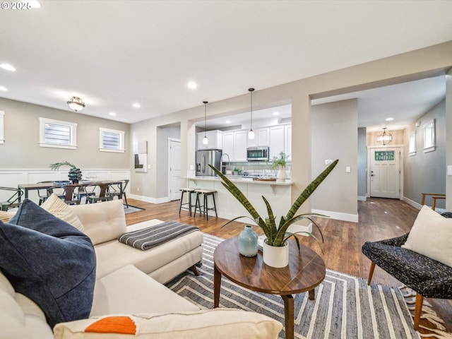 living room with recessed lighting, light wood finished floors, and baseboards