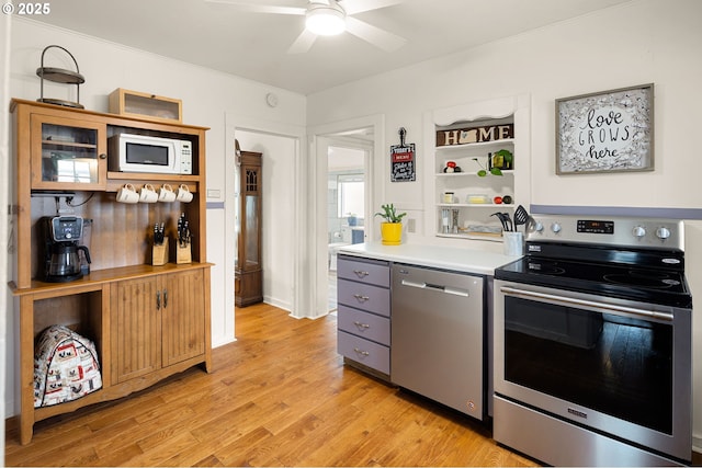 kitchen with open shelves, stainless steel appliances, light countertops, ceiling fan, and light wood-type flooring