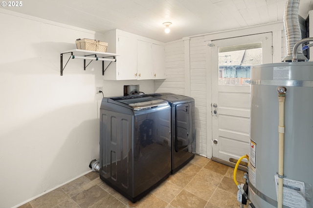 clothes washing area with washer and dryer, secured water heater, and cabinet space