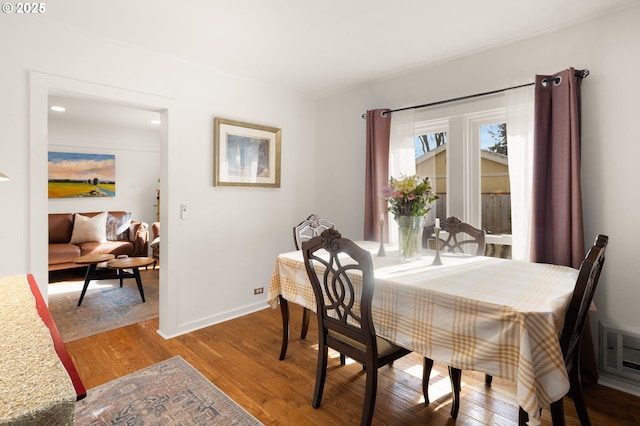 dining area with baseboards and wood finished floors