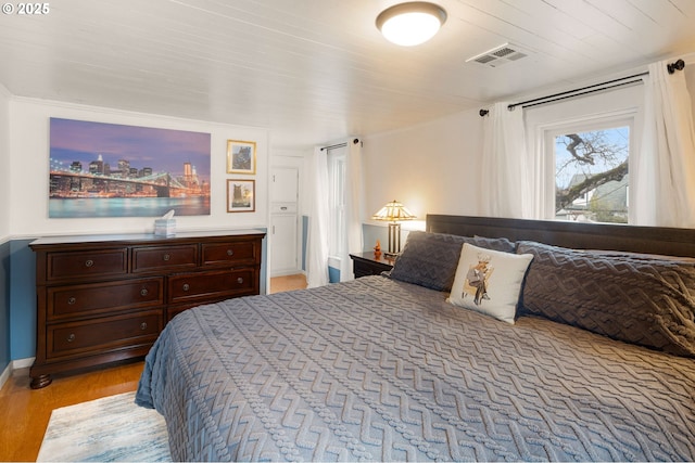 bedroom with visible vents, light wood-style flooring, and baseboards