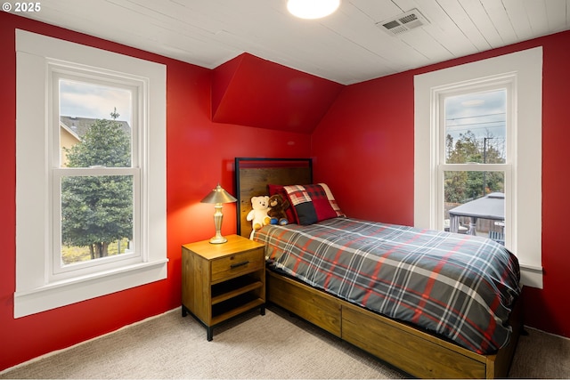 carpeted bedroom featuring multiple windows, visible vents, and vaulted ceiling