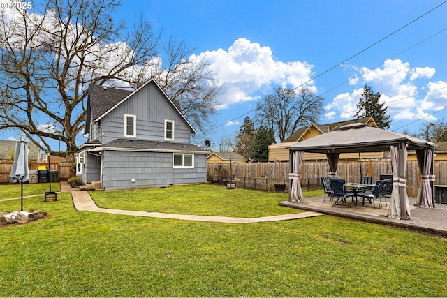 rear view of property featuring a gazebo, a lawn, a patio, and a fenced backyard