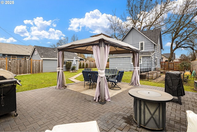 view of patio with outdoor dining space, a grill, a fenced backyard, and a gazebo