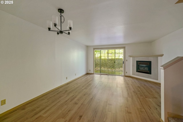 4001 12th St Cut Off SE Unit 18, Salem, OR 97302 - unfurnished living room featuring a chandelier, light wood finished floors, a tiled fireplace, and baseboards