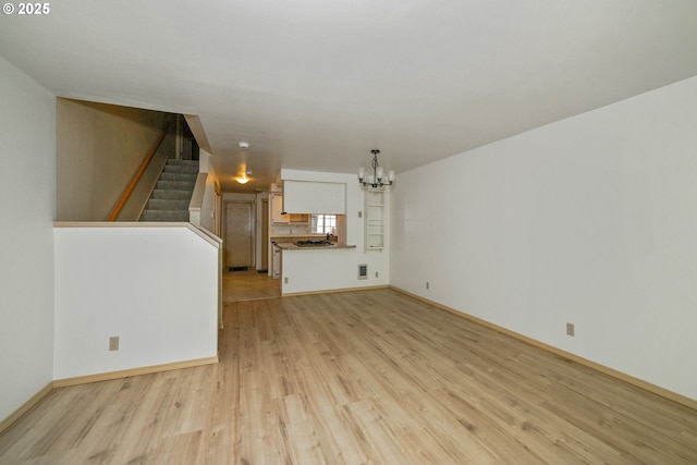 4001 12th St Cut Off SE Unit 18, Salem, OR 97302 - unfurnished living room featuring a chandelier, light wood-style floors, stairway, and baseboards