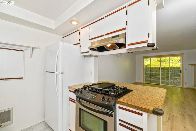 4001 12th St Cut Off SE Unit 18, Salem, OR 97302 - kitchen with stainless steel gas range, under cabinet range hood, white cabinets, heating unit, and baseboards