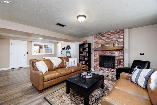 1375 NW Murray Rd, Portland, OR 97229 - living area with wood finished floors, a textured ceiling, a fireplace, and baseboards