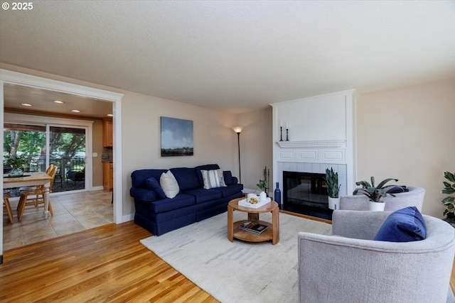 1375 NW Murray Rd, Portland, OR 97229 - living area featuring a tiled fireplace and light wood-style flooring