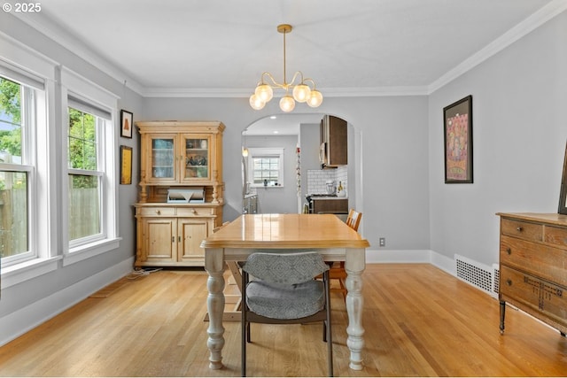 165 15th St, Salem, OR 97301 - dining area featuring arched walkways, light wood-style flooring, plenty of natural light, crown molding, and a chandelier