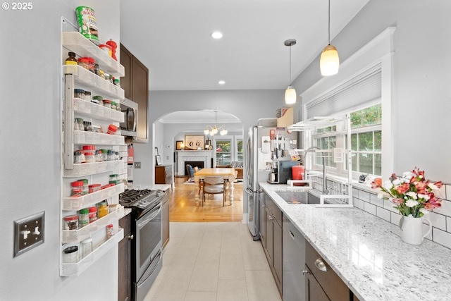 165 15th St, Salem, OR 97301 - kitchen with stainless steel appliances, arched walkways, pendant lighting, light stone countertops, and recessed lighting
